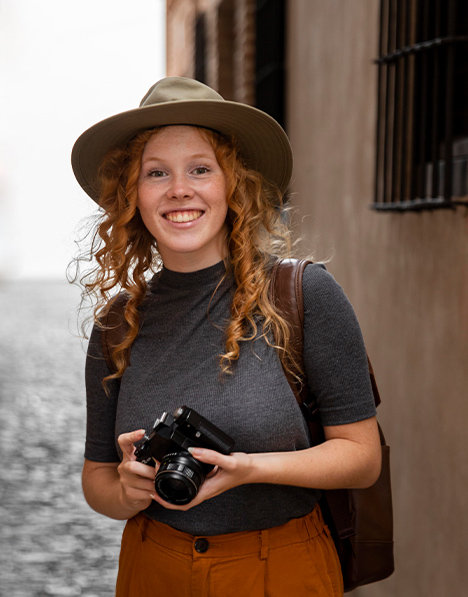 Young redhead woman holding a camera